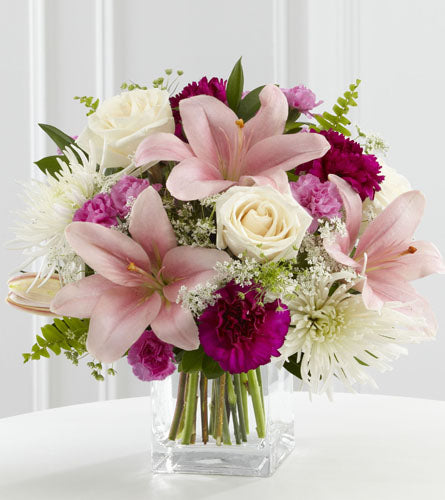 Shared Memories Bouquet - arrangement of pink lilies, white roses, and purple flowers in a clear vase.