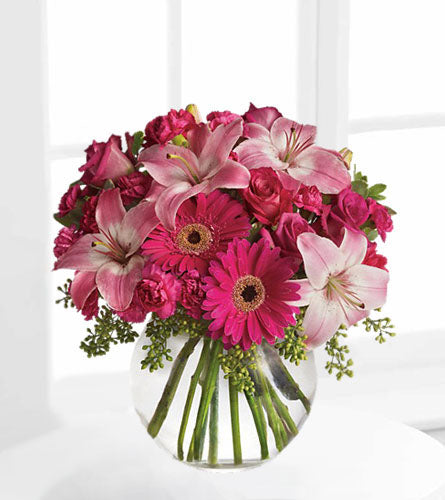 A Little Pink Me Up - bouquet of mixed pink flowers in a clear bubble bowl.