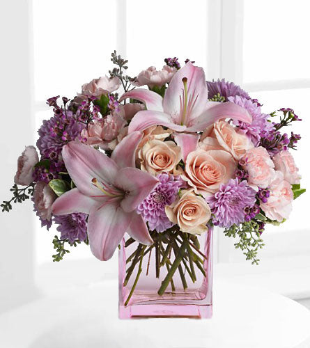 Teleflora's Possibly Pink - bouquet of pink and purple flowers in a pink glass cube.