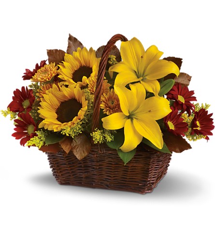 Golden Days Basket - arrangement of flowers with sunflowers, yellow lilies, and red marigolds in a dark, brown woven basket.