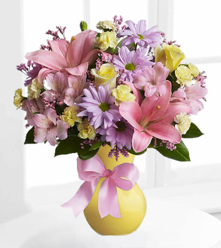 Simply Sweet - bouquet of bright colourful flowers in a yellow vase with a pink bow.