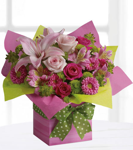 Teleflora's Pretty Pink Present - Bouquet of pink and green flowers in a wrapped pink cube with a green polka dot bow.