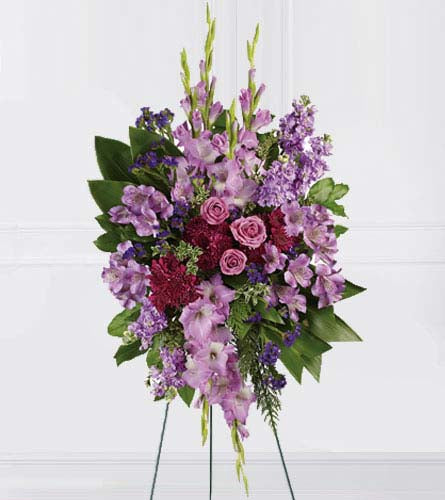 Lavender Reflections - standing funeral spray with mixed purple flowers displayed on an easel.