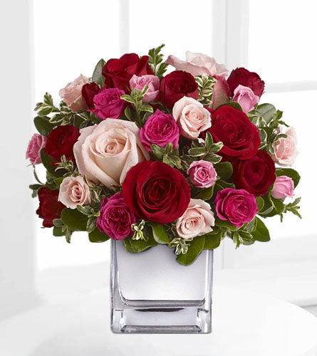 Teleflora's Love Medley - Bouquet of red, pink, and white roses in a clear glass cube.