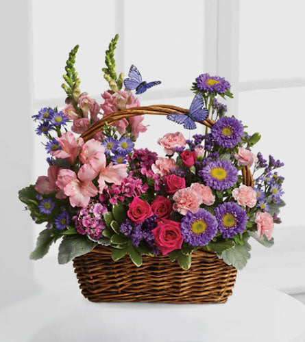 Country Basket Blooms - arrangement of colourful flowers with butterflies in a dark brown woven basket.