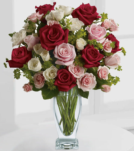 Cupid's Creation by Teleflora - Bouquet of red, pink, and white roses in a clear glass vase.