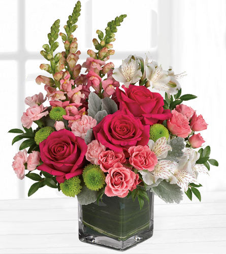 Garden Girl Bouquet - floral design of pink and white flowers with greenery in a leaf wrapped cube vase.