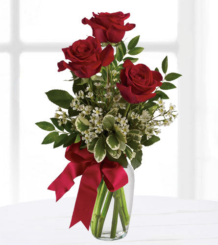 Thoughts of You - Three Roses - Bouquet of three red roses with greenery and a red ribbon in a clear vase.