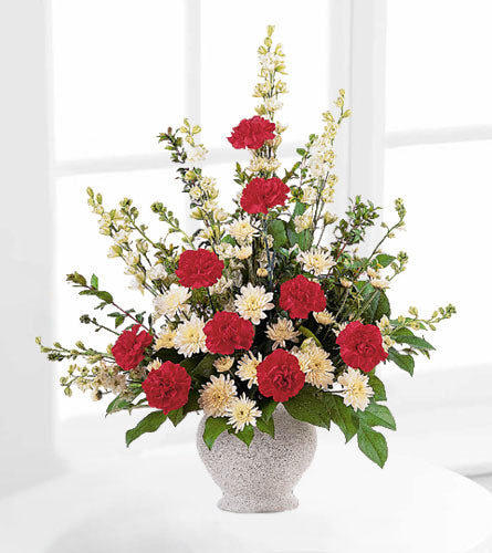 Vivid Sentiments - floral arrangement with red and white flowers with greenery in a decorative vase.