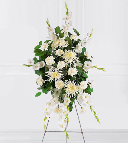 White Promises Spray - floral arrangement with white flowers and green leaves on a stand.
