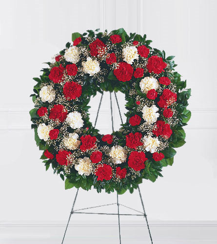 Hope and Honour Wreath - floral wreath with red and white carnations with greenery on a stand.