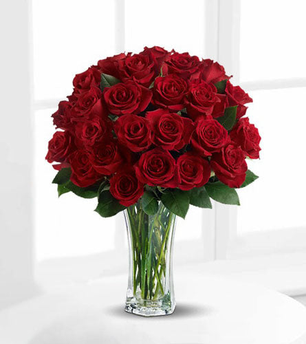 Love & Devotion - bouquet of two dozen red roses in a clear vase.