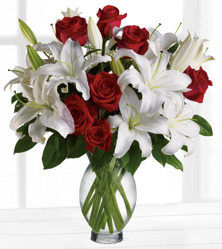 Timeless Romance - Bouquet of red roses and white lilies in a clear vase.
