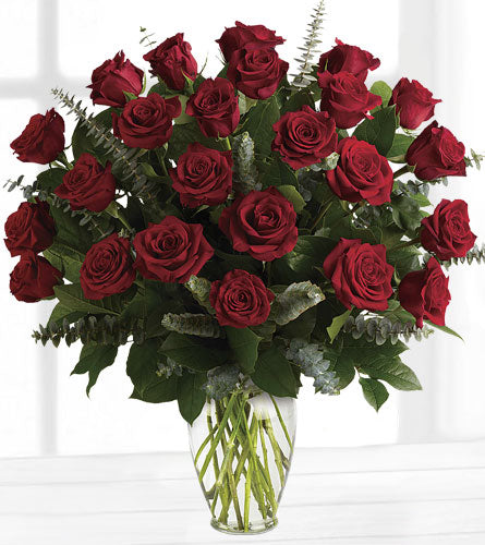 Eternal Love Premium Bouquet - two dozen red roses, eucalyptus and greenery arranged in a clear glass vase.