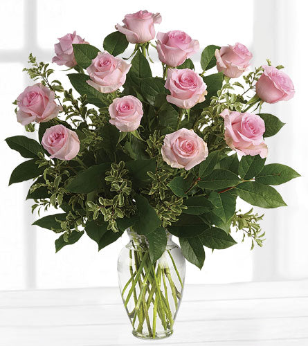 Something Sweet Bouquet - a dozen pink roses with baby's breath and greens in a clear glass vase.
