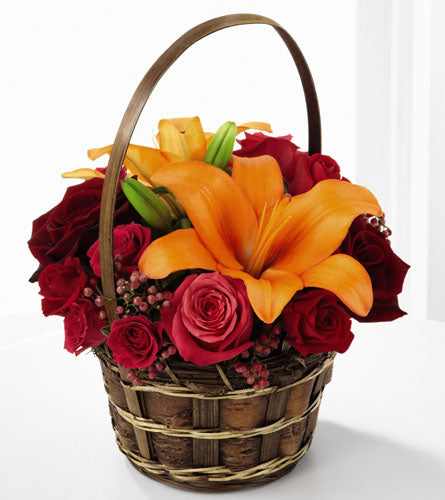 FTD's Harvest Blooms Basket - floral arrangement with orange lilies and red roses in a woven dark brown  basket.